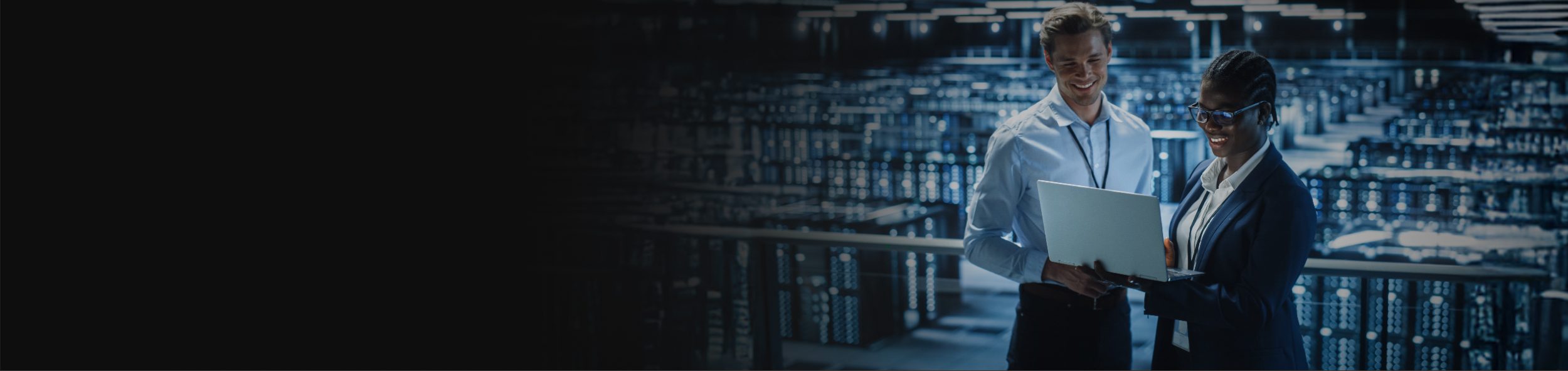 Colleagues Engaged in Discussion While Reviewing a Laptop in a High-Tech Workspace