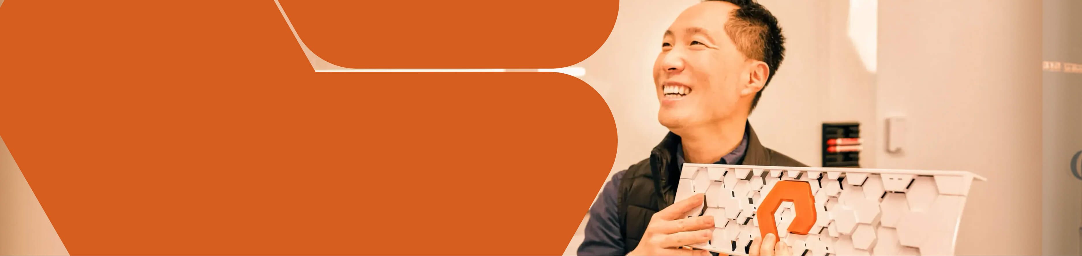 Smiling individual holding a FlashBlade bezel in a vibrant workspace