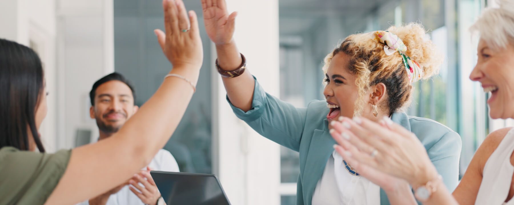 Group of colleagues celebrating a successful achievement in a bright office setting