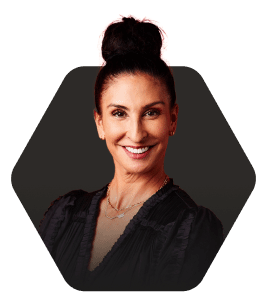 Confident woman with a sleek bun hairstyle, featured in a hexagonal frame on a dark background