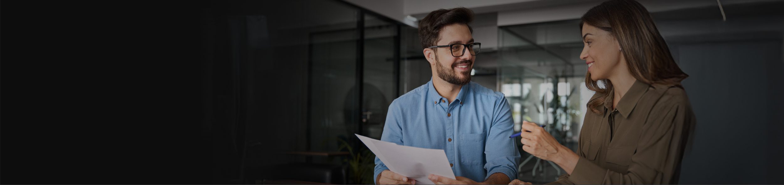 Two professionals engaged in a collaborative conversation in an office environment