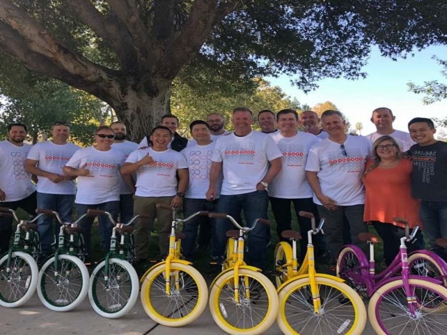 カラフルな自転車と笑顔でポーズをとる人々のグループ