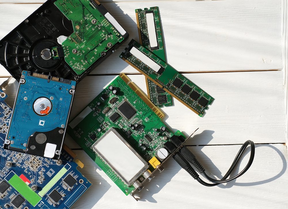 Mixed Circuit Boards and Storage Devices on a Light Wood Surface